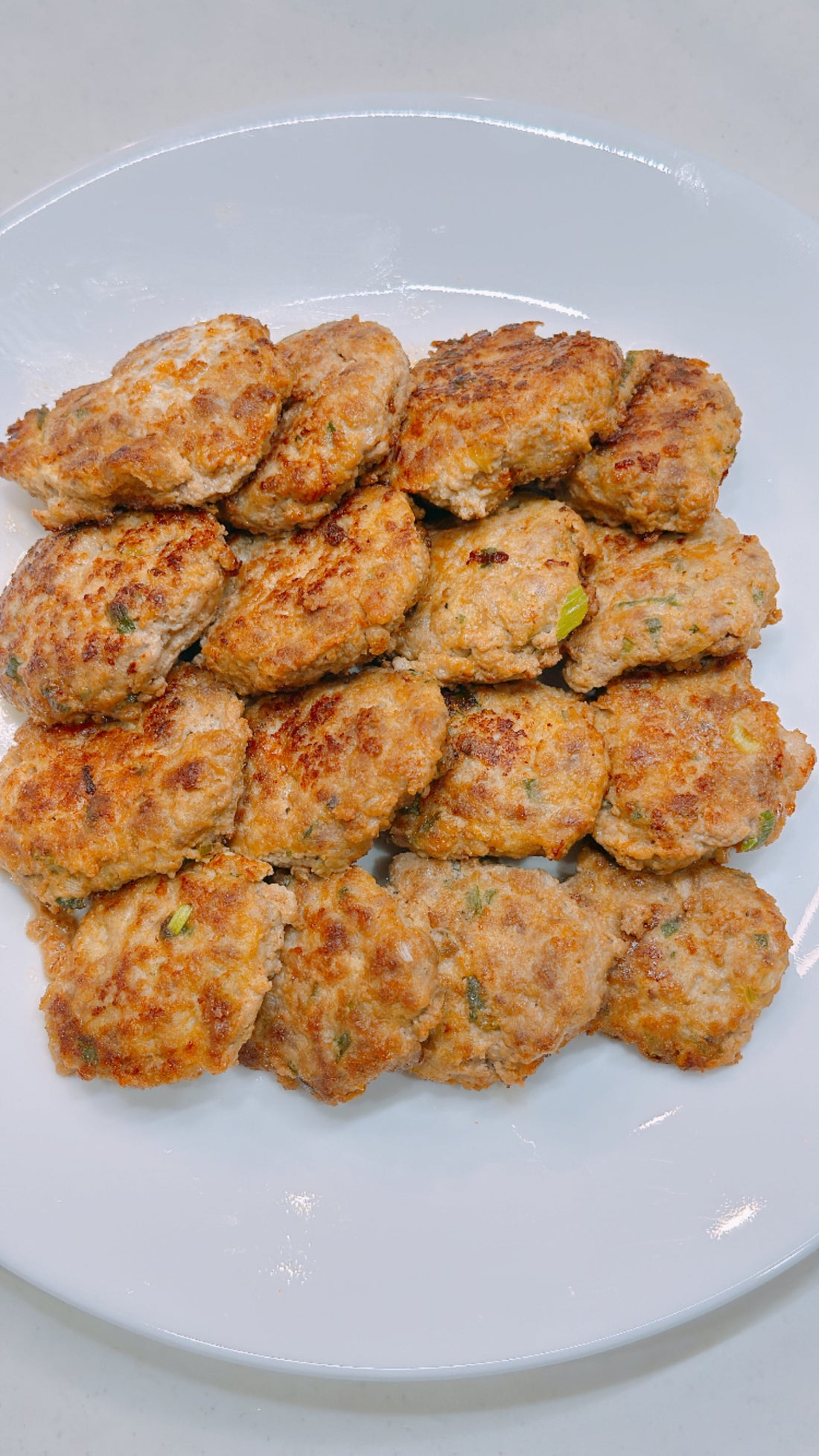白いお皿に盛り付けた、こんがり焼き色のついたドングランテン（韓国の肉チヂミ）